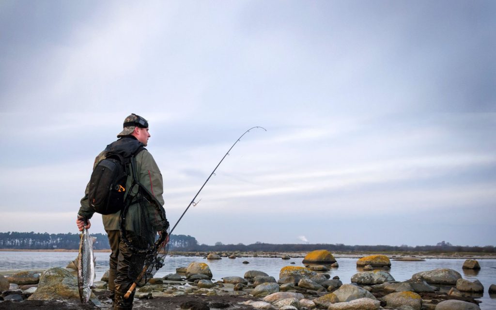 Best 8 Weight Fly Rods You Can Buy Tested - man with 8 wt fly rod on the beach saltwater fly fishing