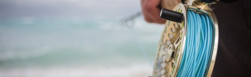 A fly rod on a beach with fly line on it.