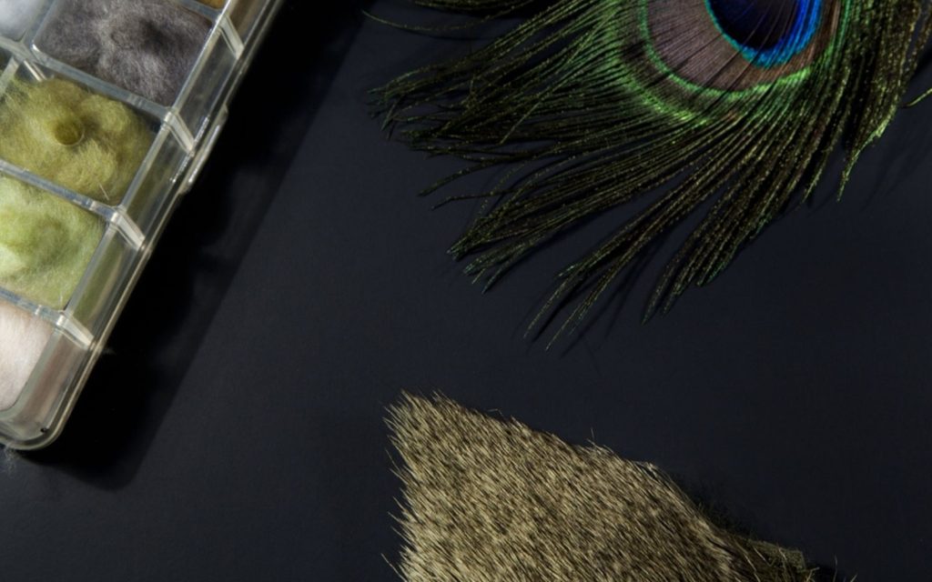 Fly tying materials on a black background