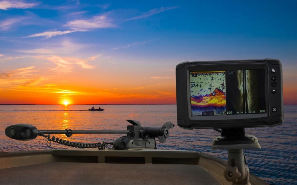 A Fishfinder GPS combo on a boat with a stunning sunrise at the background