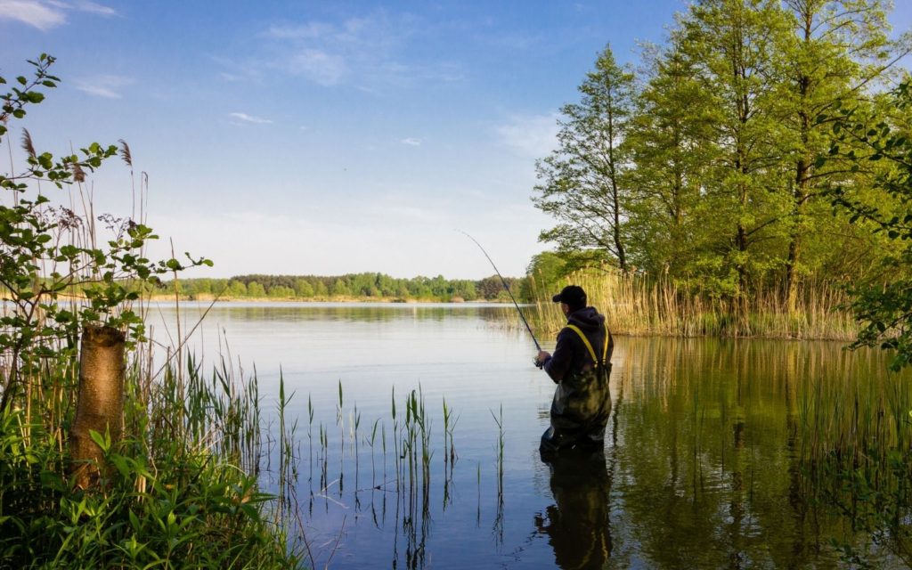 A fly angler fishing in a river wearing a breathable wader