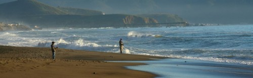 Two fly anglers surf fly fishing from a tropical beach