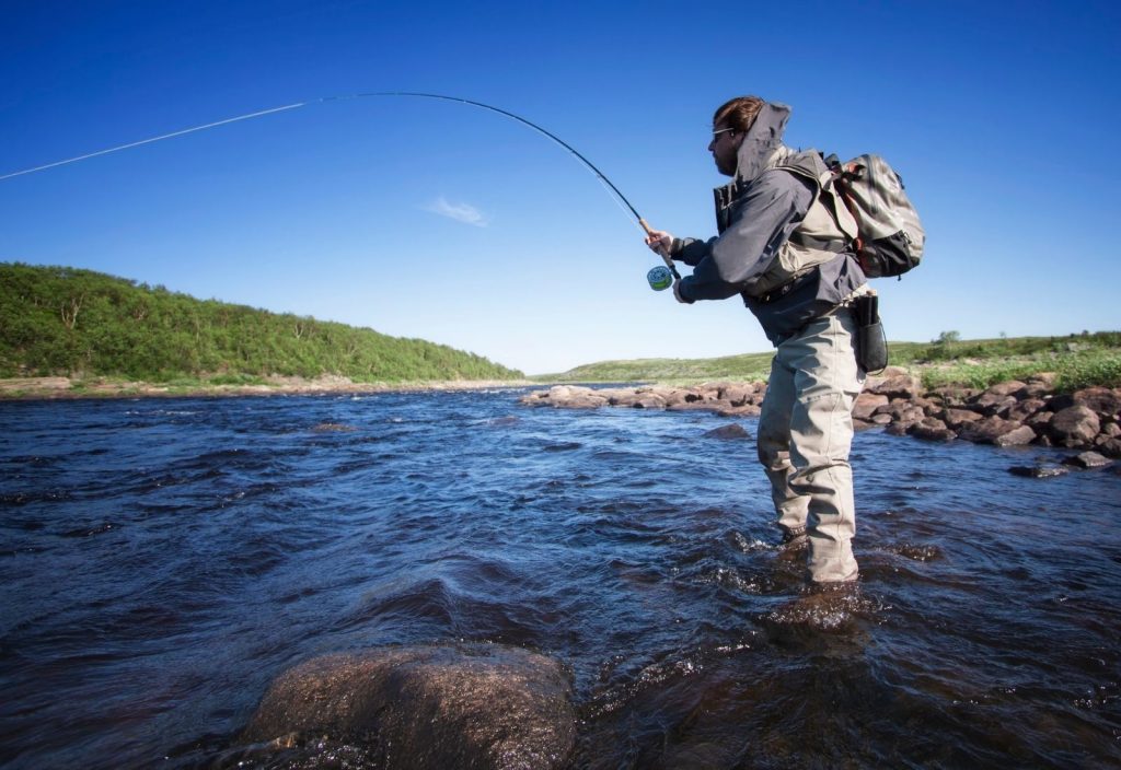 An angler fly fishing in the beautiful Maine