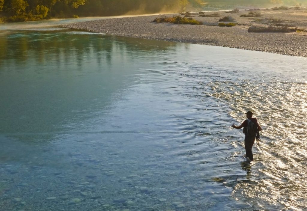 a man fly fishing on a river in Decorah