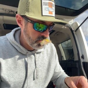 Nic tying flies and wearing his Smith Redding 2 Fishing Sunglasses