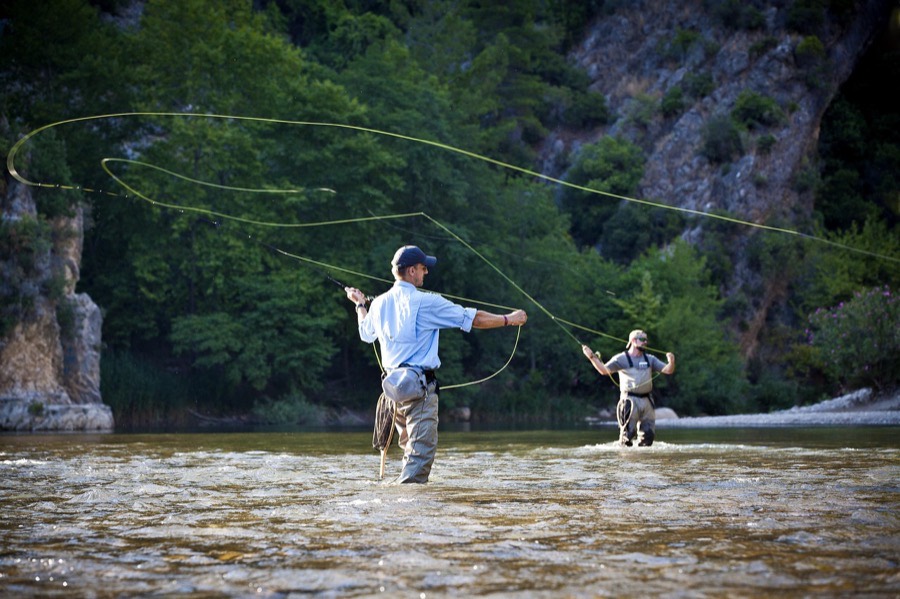 Angler casting a 5 weight fly rod on a trout river