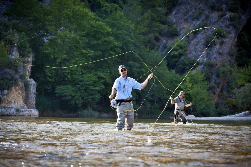 Two fly fishermen casting in the clear water of a river canyon