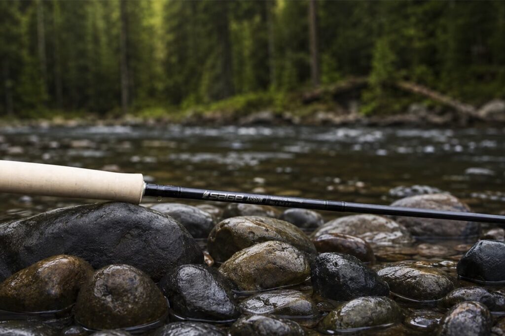 Sage Arrow 5 weight fly rod resting on wet river rocks