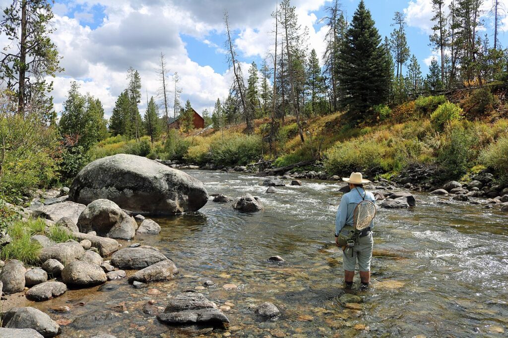 Angler fishing the Elk River beside large rocks along Seedhouse Road in Colorado.