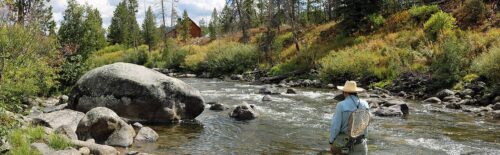 Angler fishing the Elk River beside large rocks along Seedhouse Road in Colorado.